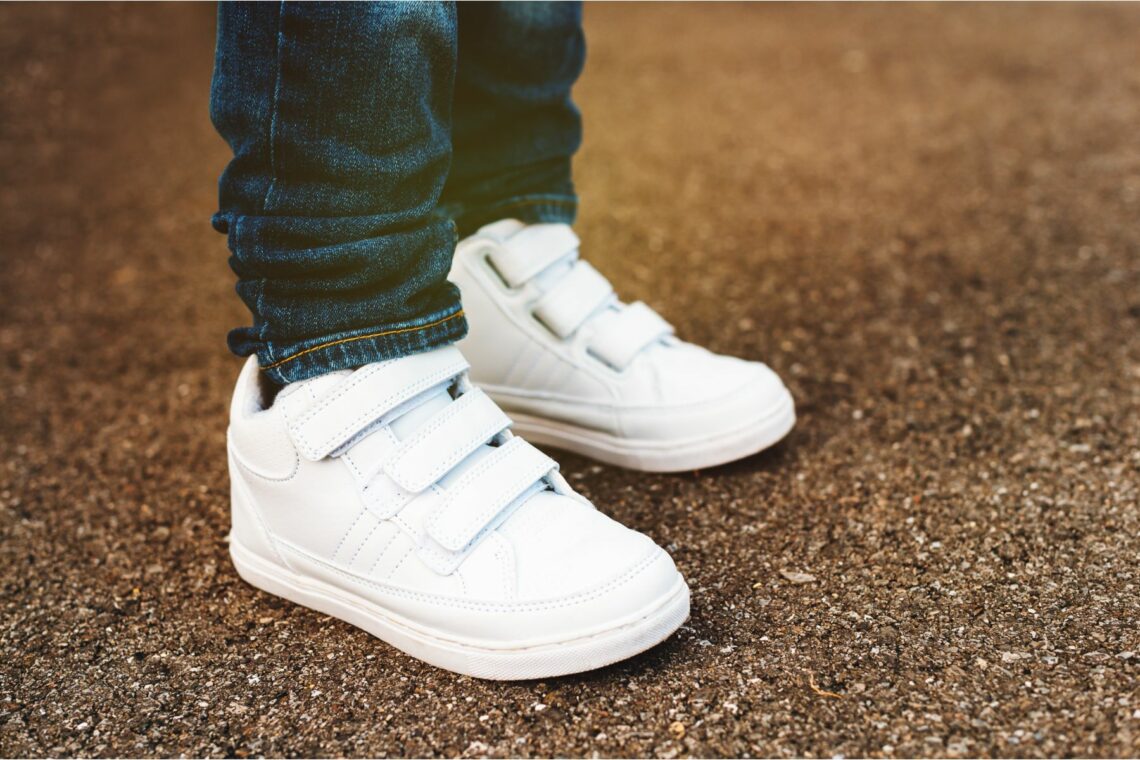 un enfant avec une paire de baskets blanches